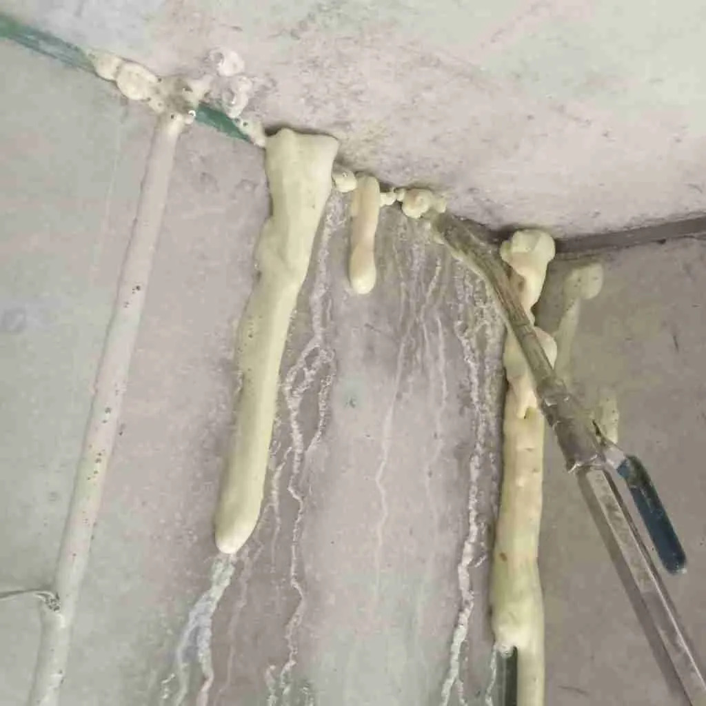 Water-reactive polyurethane injection resin expanding to stop active leakage at a concrete junction