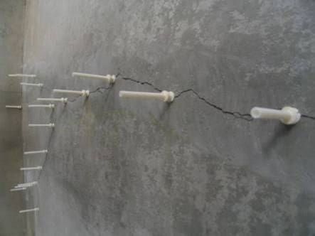 Injection packers installed at controlled spacing along a concrete wall crack